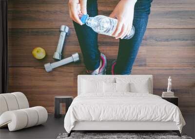 Woman with water bottle  on wooden floor background - fitness concept Wall mural