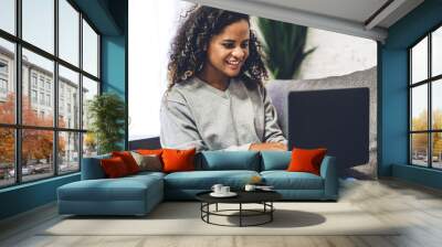 Young african american black woman relaxing and using laptop computer.woman checking social apps and working.Communication and technology concept Wall mural