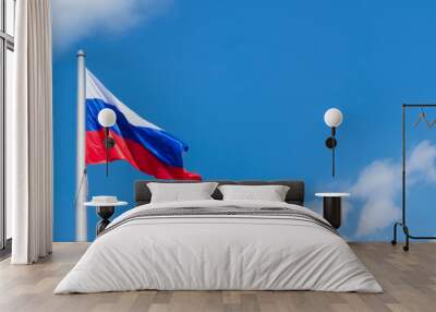 Waving flag of Russia against a blue sky background with clouds and blank space for text. Copy space. Panoramic background for banner Wall mural