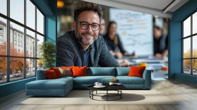 Smiling businessman sitting confidently at a conference table during a productive meeting at the office Wall mural