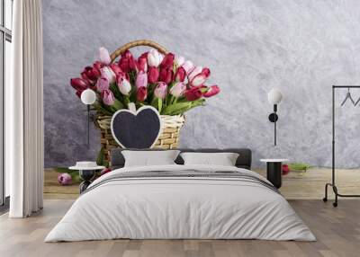 Pink and red tulip flowers in wood basket with blank wood heart Wall mural