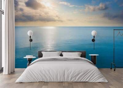 Closeup surface of calm ocean blue sea water with sunshine and clouds behind. Abstract Background Texture. Wall mural