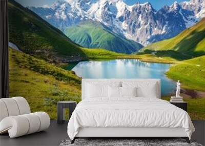 Mountain landscape of Svaneti on bright summer sunny day. Mountain lake, hills covered green grass on snowy rocky mountains background. Caucasus peaks in Georgia. Amazing view on wild georgian nature Wall mural