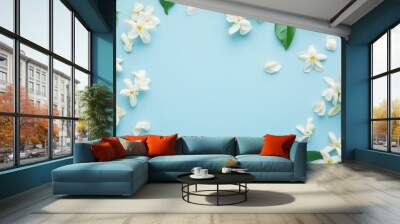 A serene arrangement of white flowers and green leaves on a light blue background. Wall mural