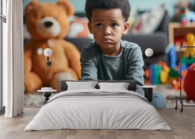 Sad African American boy sitting on the floor with toys Wall mural