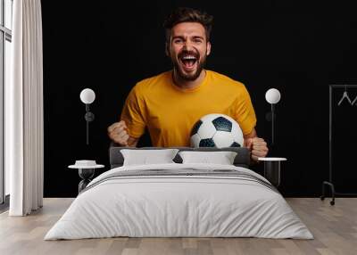 Celebrating victory, a football fan expresses joy in a vibrant yellow shirt indoors Wall mural