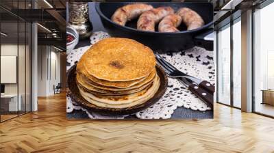 Hot pancakes with homemade sausage in frying pan Wall mural