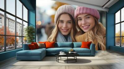 Modish young women in the city, showcasing their style with genuine smiles Wall mural