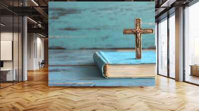 A cross resting on a book against a rustic wooden background with ample negative space Wall mural