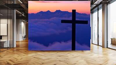 A silhouette of the crucifix against a vibrant mountain sunset casting a serene aura Wall mural