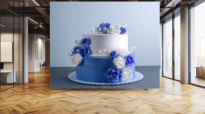 Beautiful two tiered white and blue wedding cake decorated with flowers sugar roses. Concept of elegant holiday desserts Wall mural