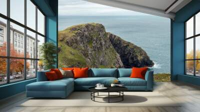 Cliffside view near Slieve League in Ireland, featuring rugged rocks, green slopes, and the Atlantic Ocean stretching to the horizon Wall mural