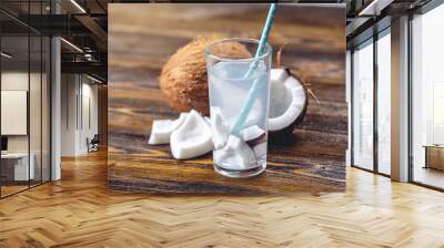 Coconut water in the composition with white flesh on wooden background. Organic product widely used in cosmetology Wall mural