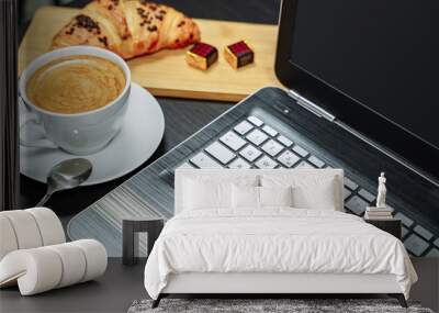 Coffee, croissant and laptop on the table. Breakfast. Wall mural