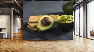 Cold appetizer of mashed avocado flesh with bread on the table. Traditional mexican food from organic eco products Wall mural