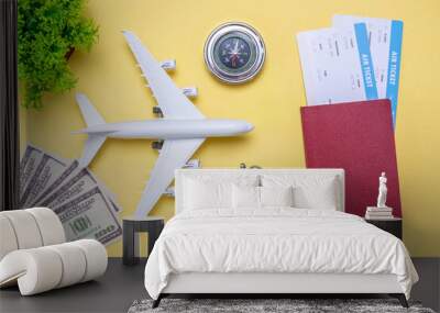 Layout of accessories for vacation and travel. Air tickets, money and documents on a yellow background Wall mural