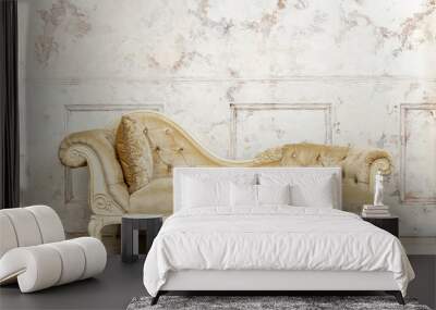 Luxurious golden sofa on a background of old white wall Wall mural