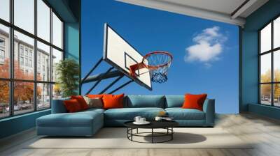 Outdoor basketball hoop under clear blue sky at sports court Wall mural