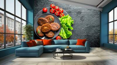 Cutlets with cherry tomatoes and salad leaves. Wall mural