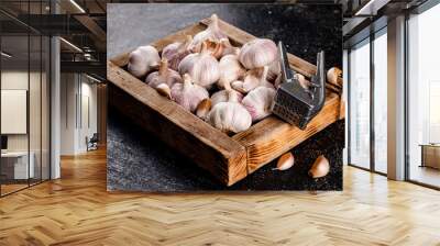 Garlic on a wooden tray with a garlic press. Wall mural