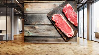 Raw beef steaks on cutting Board. Wall mural