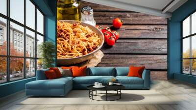 Spaghetti bolognese in a plate on a table with tomatoes.  Wall mural