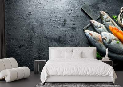 Various fresh fish on a cutting Board with spices, parsley, garlic and lime. Wall mural