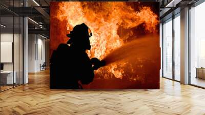 Silhouette of Firemen fighting a raging fire with flames. Forest fire. Wall mural