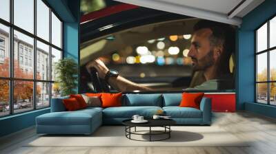 The attractive man is sitting in the car Wall mural