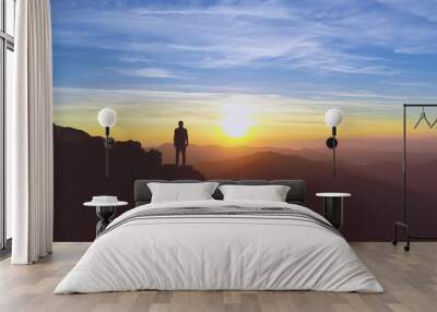 The man standing on the mountain on the picturesque sunrise background Wall mural