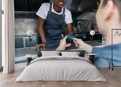 Close up of male customer apply a credit card to POS terminal at a food truck Wall mural