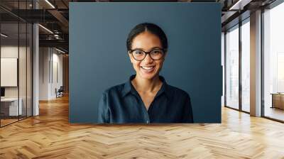 Portrait of a beautiful businesswoman wearing spectacles and looking at camera in living room Wall mural