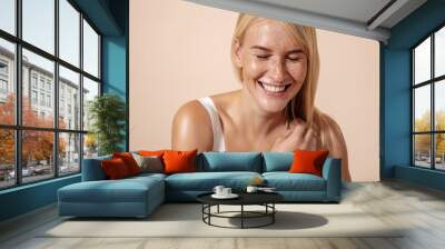 Studio shot of a happy caucasian woman adjusting her hair with closed eyes Wall mural