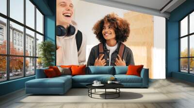 Two laughing teenagers in college. Smiling girl looking at her classmate in corridor. Wall mural