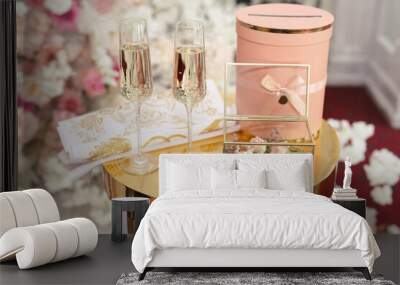 A box with wedding rings and gold sequins, champagne glasses, flowers. Wall mural