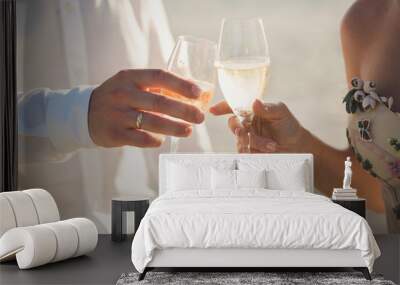 Bride and groom are holding champagne glasses Wall mural