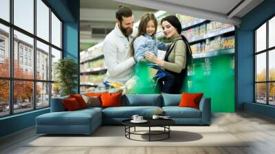 Family with shopping cart with food visiting supermarket Wall mural