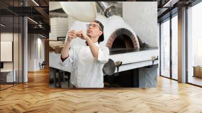 Pizza Chef makes the pizza dough spin in the air to make it thin and soft. Wall mural