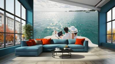 Two business people working with laptop on a sailing boat - sailing trip. Wall mural