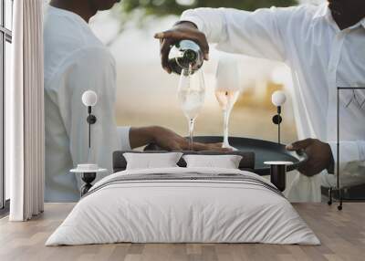 Waiter pouring champagne into glass. Wall mural