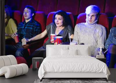 Young scared couple at the cinema watching an horror movie Wall mural