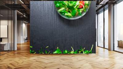 fresh raw greens on dark background with bowl with salad Wall mural