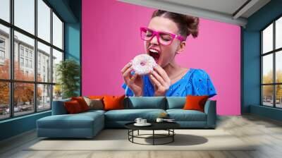 Girl angrily biting a sprinkled doughnut Wall mural