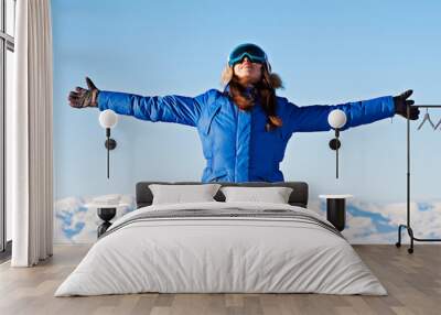 woman standing against snowy mountains and blue sky Wall mural