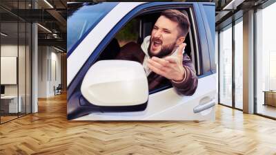 young man shouting from the window of his car Wall mural