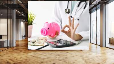 Medical and health insurance concept, Doctor holding piggy bank and money in hospital background, Money saving for medical care expenses. Wall mural