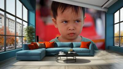 Angry little asian boy showing frustration and disagreement. Mad kid got upset and sad and he has a negative attitude. Depressed boy complaining. Wall mural