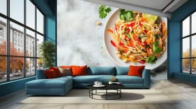 A colorful papaya salad with peanuts, lime, and chili, shot from above on a white plate, with open space on the side for copy. Wall mural