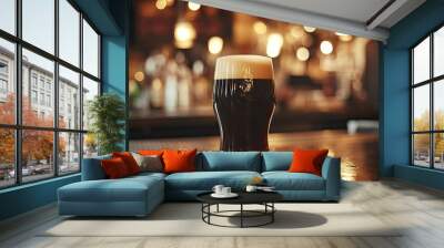 A perfectly poured stout with a creamy head, illuminated by the bar's soft lights. Wall mural