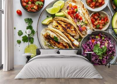 A vibrant fish taco platter with grilled fish, fresh slaw, and avocado, served with lime wedges and salsa on a white table. Wall mural